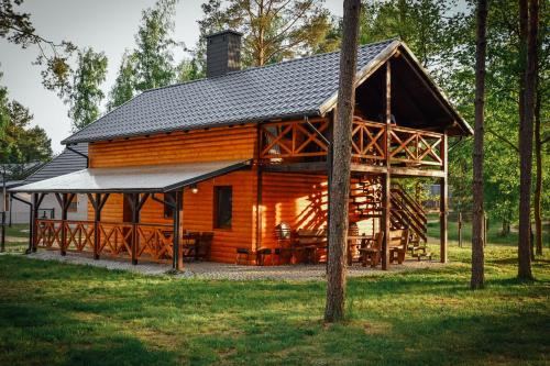 Cabaña de madera con techo negro en Domek letniskowy SZWED-POL, en Kujan
