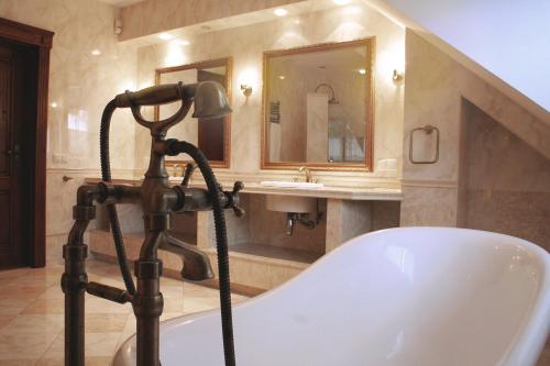 a bathroom with a bath tub and a sink at Villa Sofia in Kraków