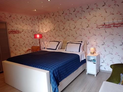 um quarto com uma cama com um edredão azul em Les Ecureuils em Revin