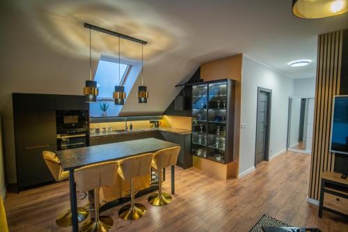 kuchnia ze stołem i krzesłami w pokoju w obiekcie Apartament w Cieplicach 6 Gold w Jeleniej Górze