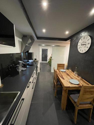 a kitchen with a wooden table and a clock on the wall at 2-Zimmer Wohnung an der Lindenstraße in Lengerich