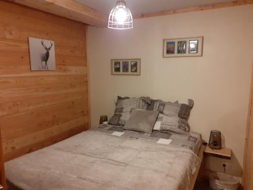 um quarto com uma cama e uma parede de madeira em Appartement chaleureux avec wifi de 10 personnes à Val-Cenis em Lanslebourg-Mont-Cenis