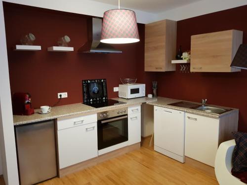 uma pequena cozinha com armários brancos e um micro-ondas em BullsLiving Kaisermühlen Apartment Erni next to UNO City em Viena