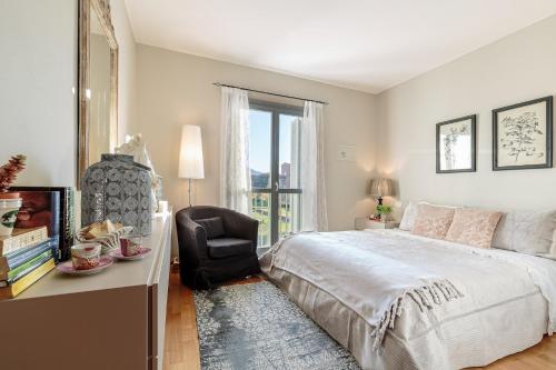 Un dormitorio con una cama y una silla y una ventana. en Casa Piccionaia, Luxury Home with Free Private Parking inside Lucca, en Lucca