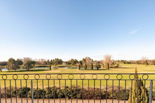 uma vista para um campo de golfe a partir de uma cerca em Residhotel Golf Grand Avignon em Vedène
