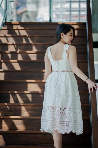 a woman in a white dress walking down stairs at Play Poshtel & Cafe' in Krabi town
