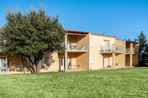 an exterior view of a large building with a tree at Residhotel Golf Grand Avignon in Vedène