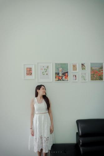 a woman in a white dress standing in a room at Play Poshtel & Cafe' in Krabi town
