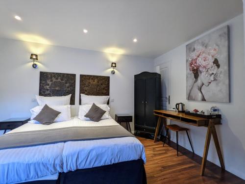 a bedroom with a large bed and a desk at Chambres d'Hôtes La Filature in Saint-Quentin