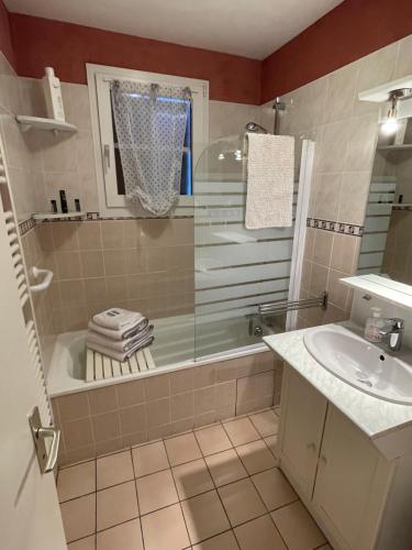a bathroom with a shower and a tub and a sink at Les Prairies du lac in Gérardmer