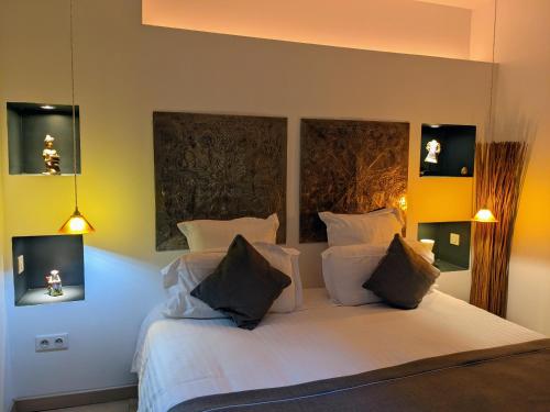 a bedroom with a large white bed with two pillows at Chambres d'Hôtes La Filature in Saint-Quentin