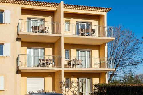 a building with chairs and tables on the balconies at Residhotel Golf Grand Avignon in Vedène