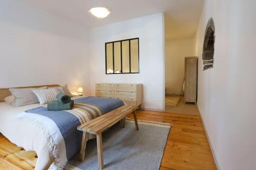 Schlafzimmer mit einem Bett und einer Holzbank in der Unterkunft Le Thiou 3 étoiles - Charmant & Authentique, Au Cœur de la Vieille Ville, Billard, 6 personnes in Annecy