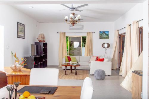 sala de estar con sofá blanco y lámpara de araña en Riverside Mount Simpson - Seychelles Island en Mahe