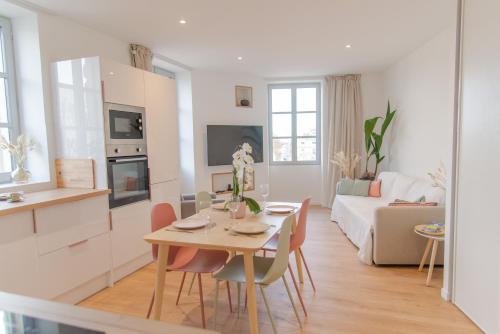 een keuken en een woonkamer met een tafel en stoelen bij La Vue des Papes - Hypercentre - Parking in Avignon