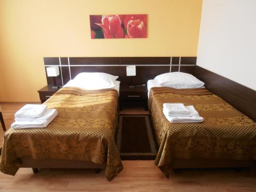 a hotel room with two beds with towels on them at Villa Ramzes in Gdańsk