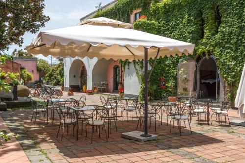 a group of tables and chairs under an umbrella at Etna Hotel in Giarre