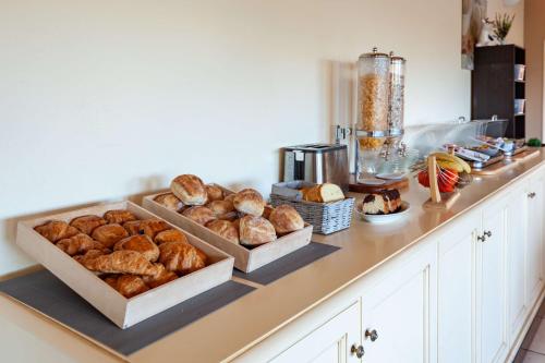 a counter with two trays of bread and other pastries at Residhotel Golf Grand Avignon in Vedène