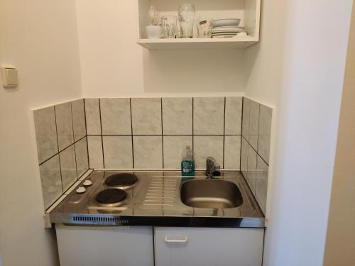 eine kleine Küche mit einer Spüle und einem Herd in der Unterkunft modern apartment in Wien