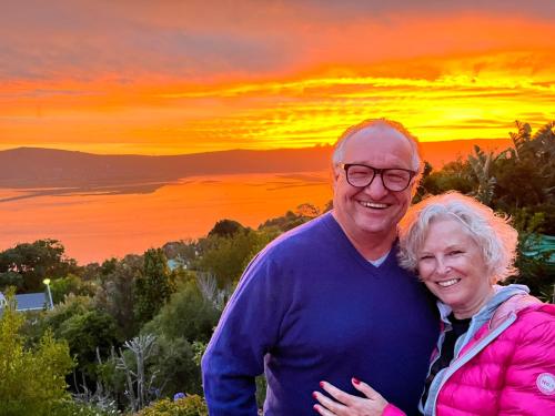 an older man and woman standing in front of a sunset at Paradise Found in Knysna