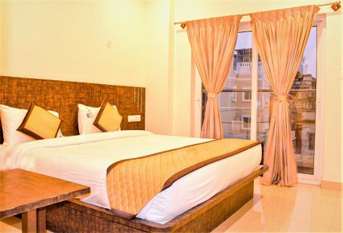 Postel nebo postele na pokoji v ubytování Sai Vihaar Inn & Suites
