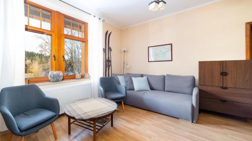 a living room with a couch and two chairs at Prywatne apartamenty Sun & Snow z mini SPA in Szklarska Poręba