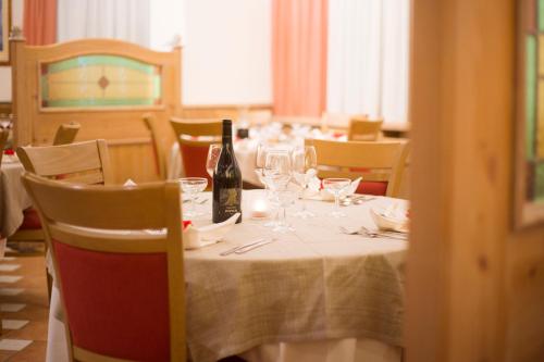 a table with a bottle of wine and glasses on it at Hotel Stella Alpina in Andalo