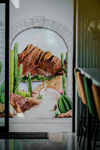 a mural of a desert with cacti at Play Poshtel & Cafe' in Krabi town