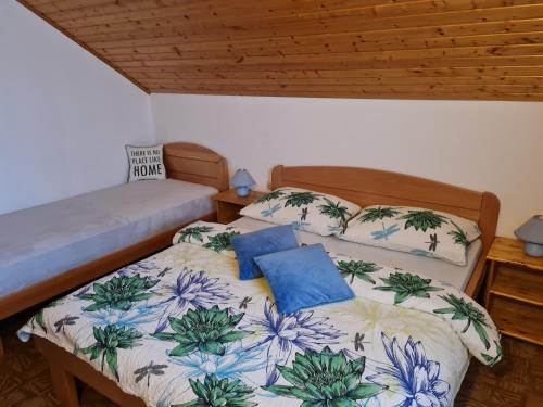 a bedroom with two beds with blue pillows at Apartment Charlie in Seliste Dreznicko
