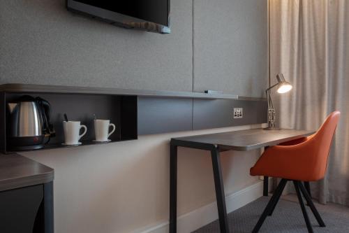 a kitchen with a desk and a chair and a table at Holiday Inn Bolton Centre by IHG in Bolton