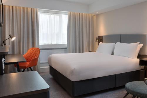a hotel room with a large bed and a desk at Holiday Inn Bolton Centre by IHG in Bolton