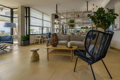 a living room with a couch and a table and chairs at Best Western Plus Ajaccio Amirauté in Ajaccio