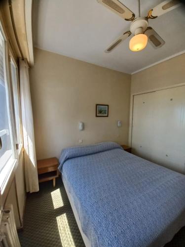 a bedroom with a blue bed and a ceiling fan at Hotel King's in Mar del Plata