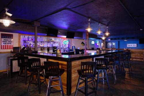 a bar with a bunch of bar stools at Ramada by Wyndham Sarasota Waterfront in Sarasota