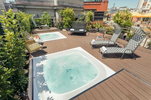 a hot tub sitting on a deck with chairs at Generator Madrid in Madrid