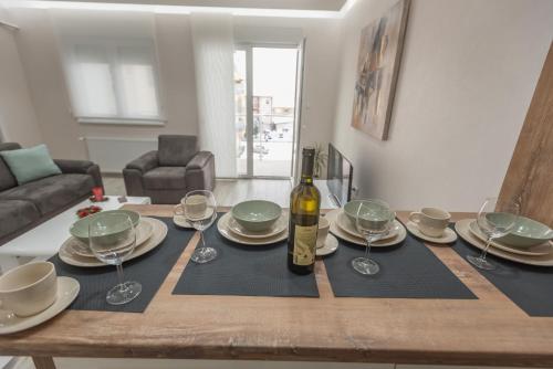 a dining room table with a bottle of wine on it at Apartment Ekatarina in Banja Koviljača
