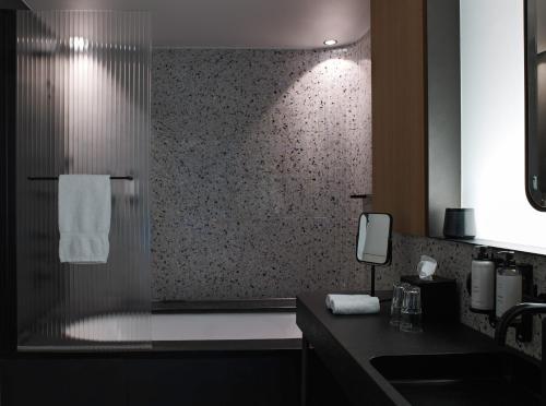 a bathroom with a shower with a sink and a mirror at Hôtel National Des Arts et Métiers in Paris