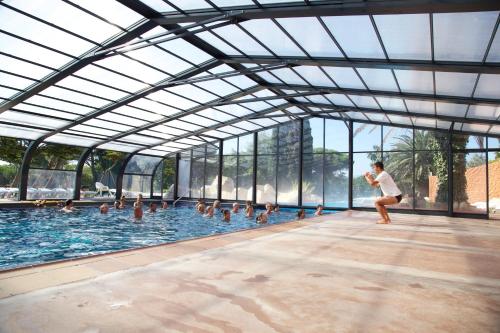 a man running in a swimming pool with ducks at Mobil Home Luxe 3 chambres climatisé Canet en Roussillon in Canet-en-Roussillon