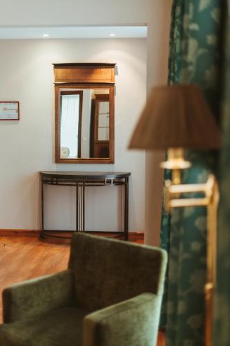 a living room with a chair and a mirror at Barceló León Conde Luna in León