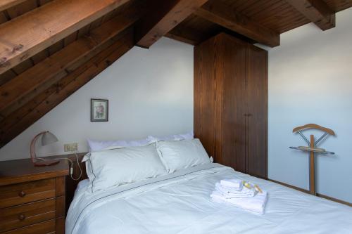 a bedroom with a bed with a cross on the wall at Asiago Millepini - Mansarda sull'Altopiano in Asiago