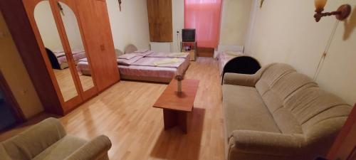 a living room with a couch and a bed at Szent István Panzió in Hódmezővásárhely