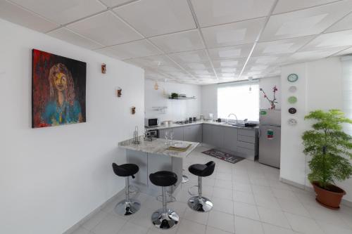a kitchen with a counter and stools in a room at A Casa da Mizi in Praia