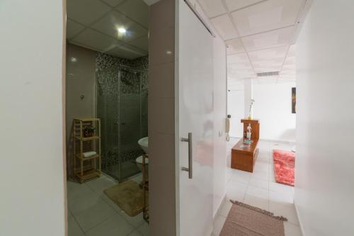 a white bathroom with a shower and a sink at A Casa da Mizi in Praia