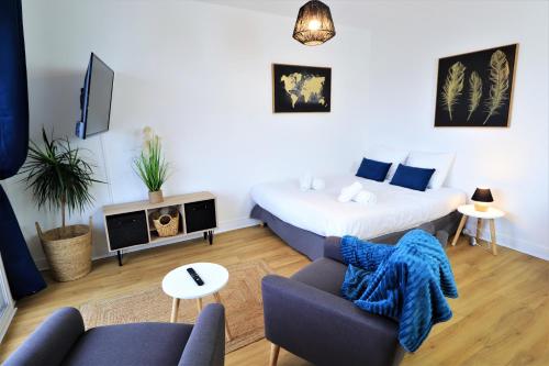 uma sala de estar com uma cama e um sofá em L'ECRIN Logement tout confort wifi, centre-ville, parking privé em Vannes