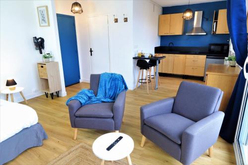 Il comprend un salon avec deux chaises et une cuisine. dans l'établissement L'ECRIN Logement tout confort wifi, centre-ville, parking privé, à Vannes