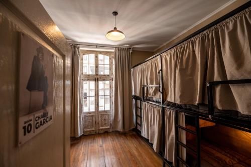 um quarto com uma janela e uma porta com cortinas em Che Juan Hostel BA em Buenos Aires