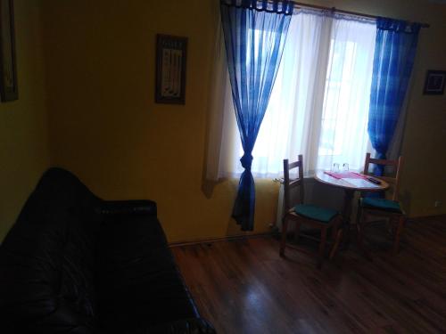 a living room with a table and a window at Penzion Olga in Mariánské Lázně