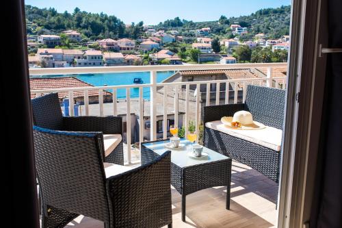 uma varanda com mesa e cadeiras e vista para a água em Apartments Sunshine Home em Vela Luka