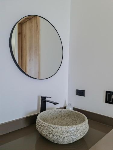a bathroom with a stone sink and a mirror at Hotel Arbóreo Doradal in Doradal