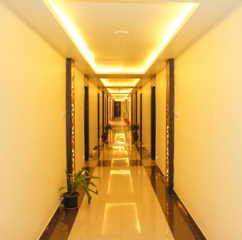 a hallway of a building with a plant in it at Sai Vihaar Inn & Suites in Mysore